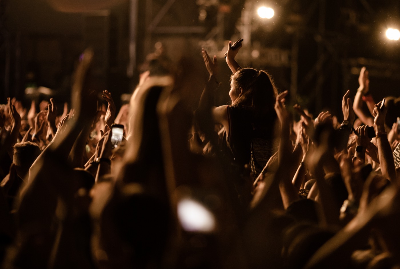 Festival crowd in front of a lit stage at night